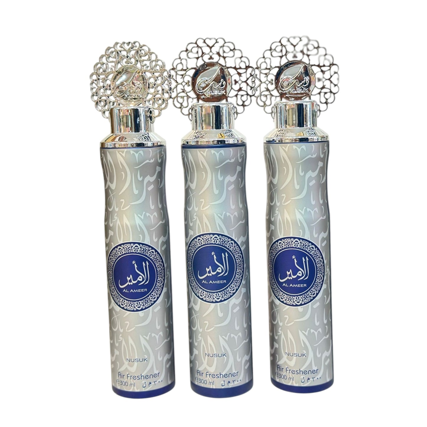 Three bottles of Al Ameer air freshener with decorative caps and intricate patterns on the bottles.