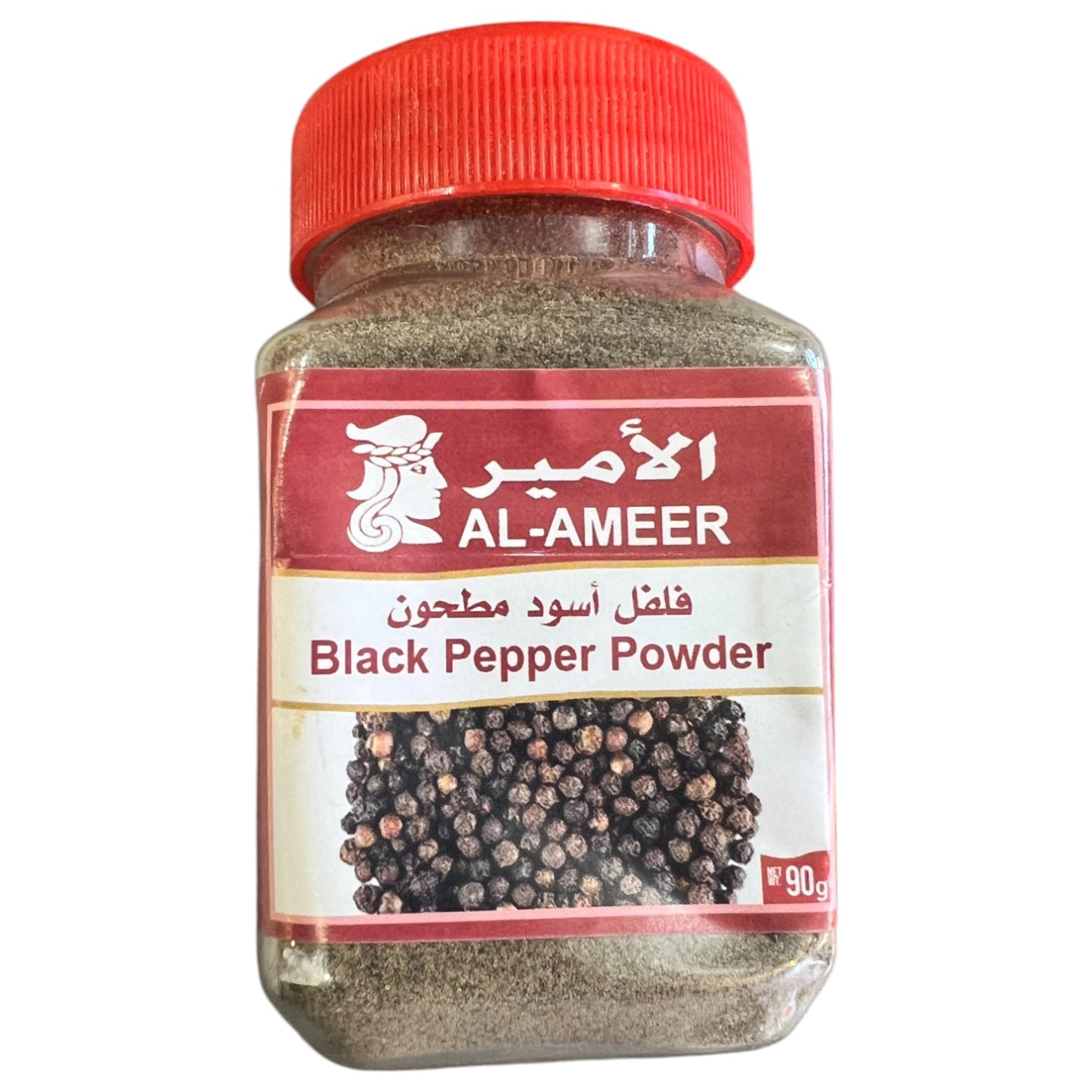 A plastic jar of Al-Ameer black pepper powder with a red lid. The label shows the brand name and product name, and the jar is filled with whole black peppercorns visible through the transparent body.