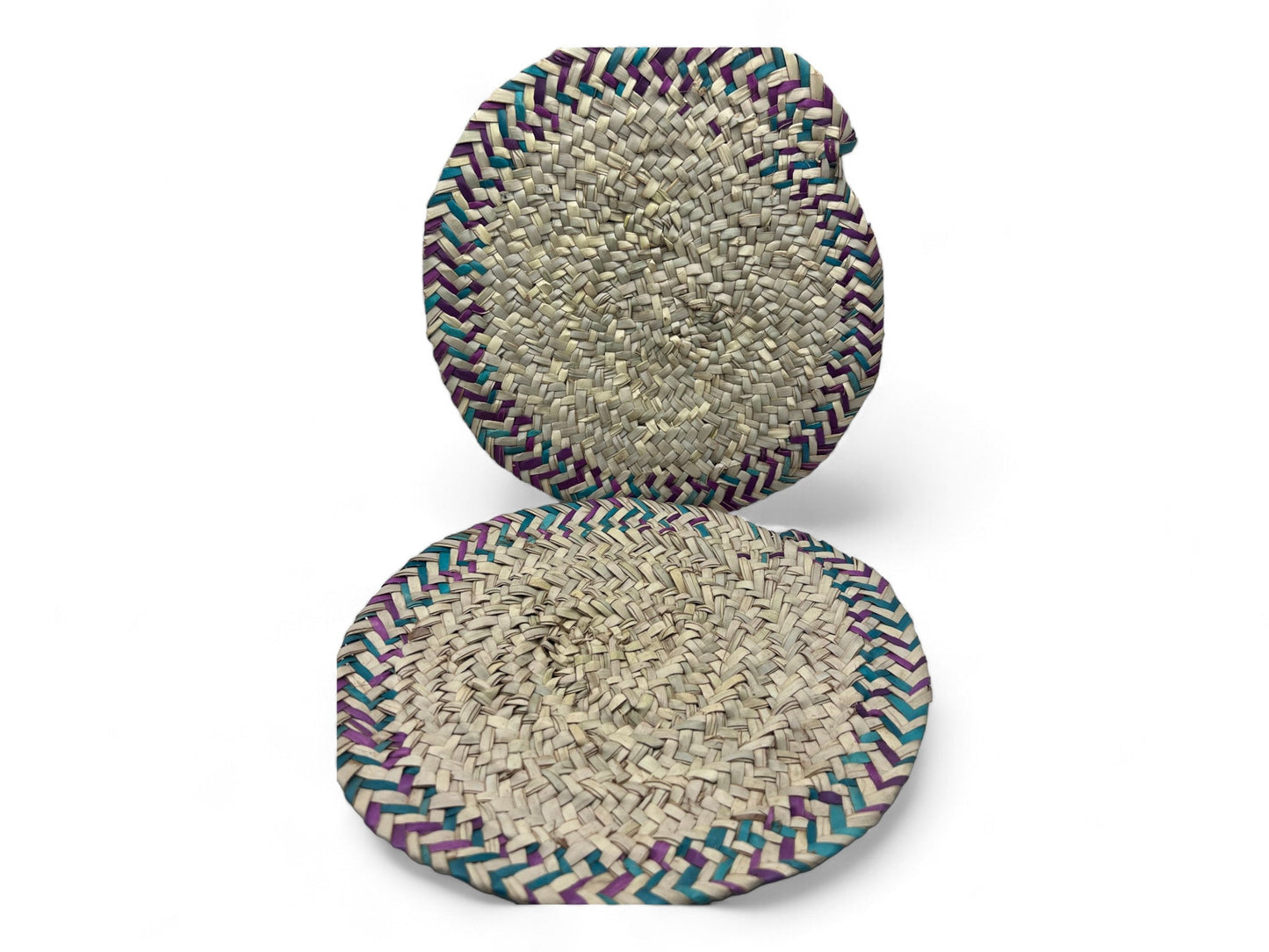 Two traditional woven palm leaf fire fans with multicolored edges.
