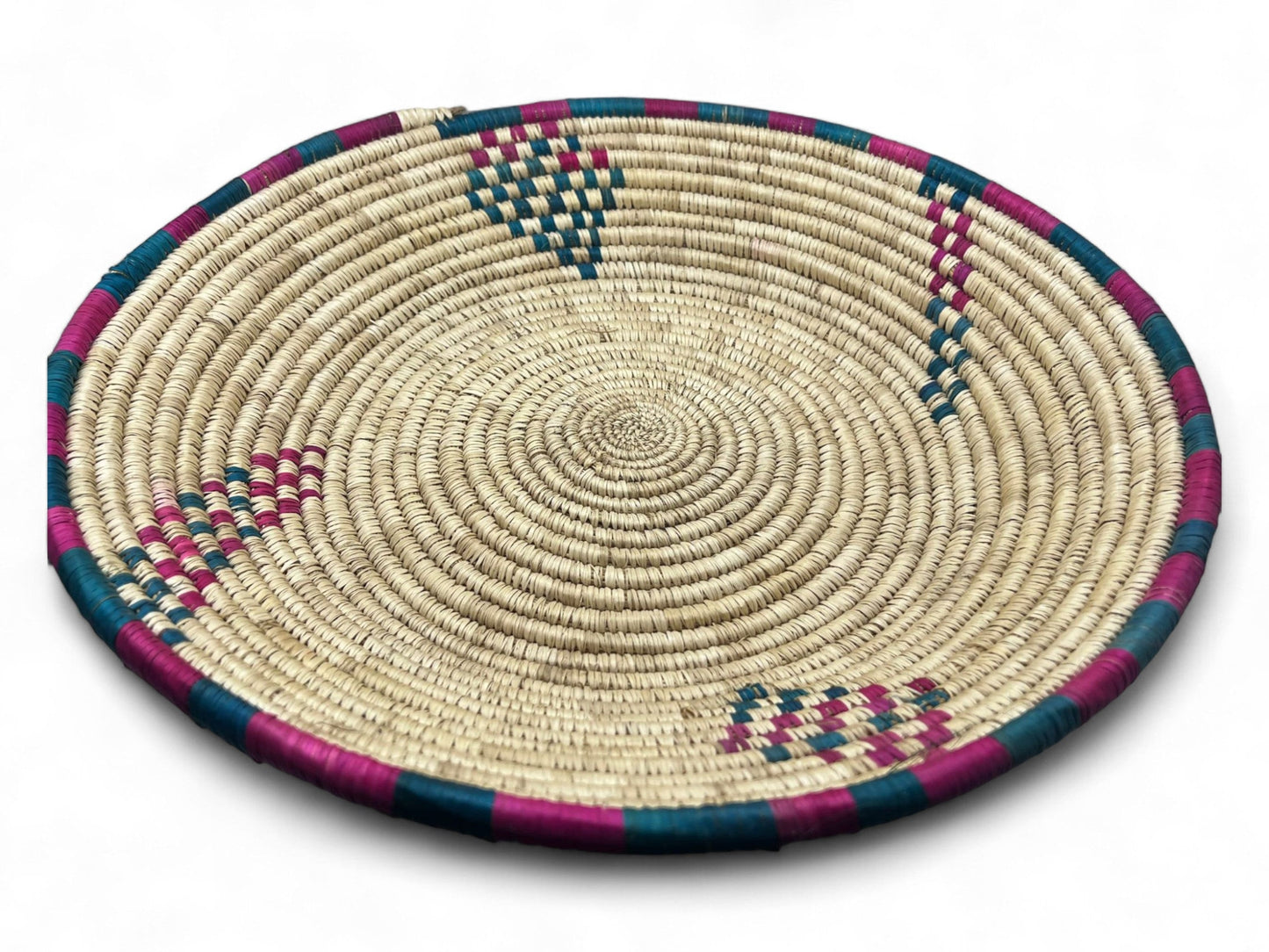 A woven palm leaf snack tray with geometric patterns primarily in beige, with blue and pink accents.