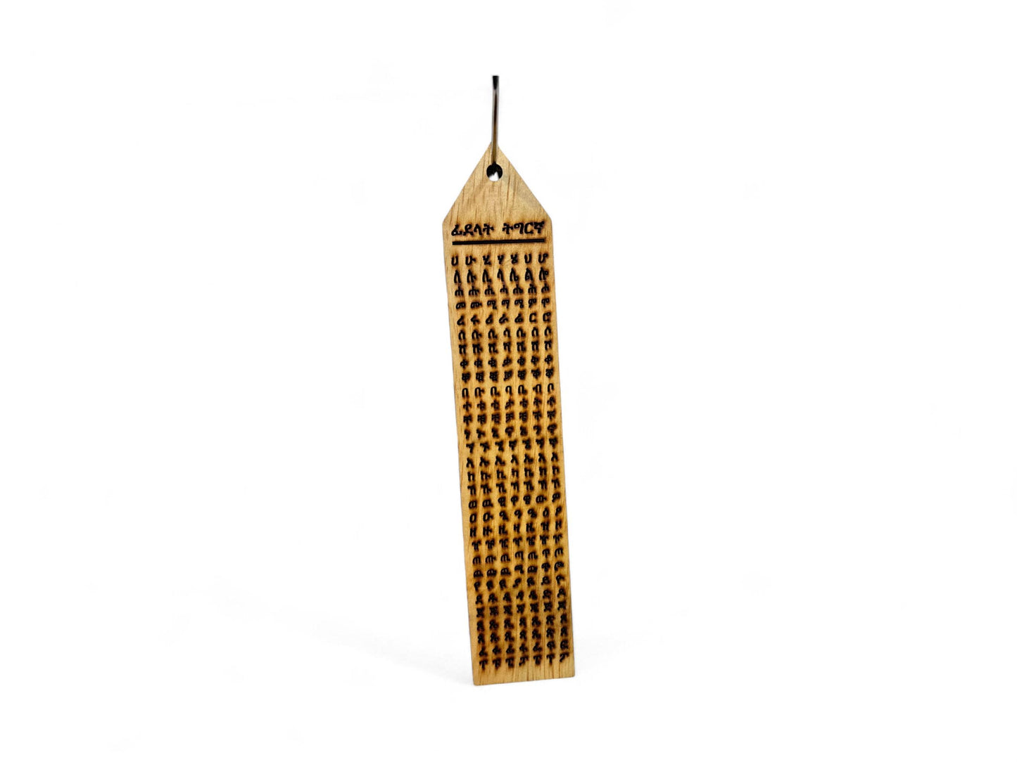 A wooden wall hanging art piece with Tigrinya alphabets.