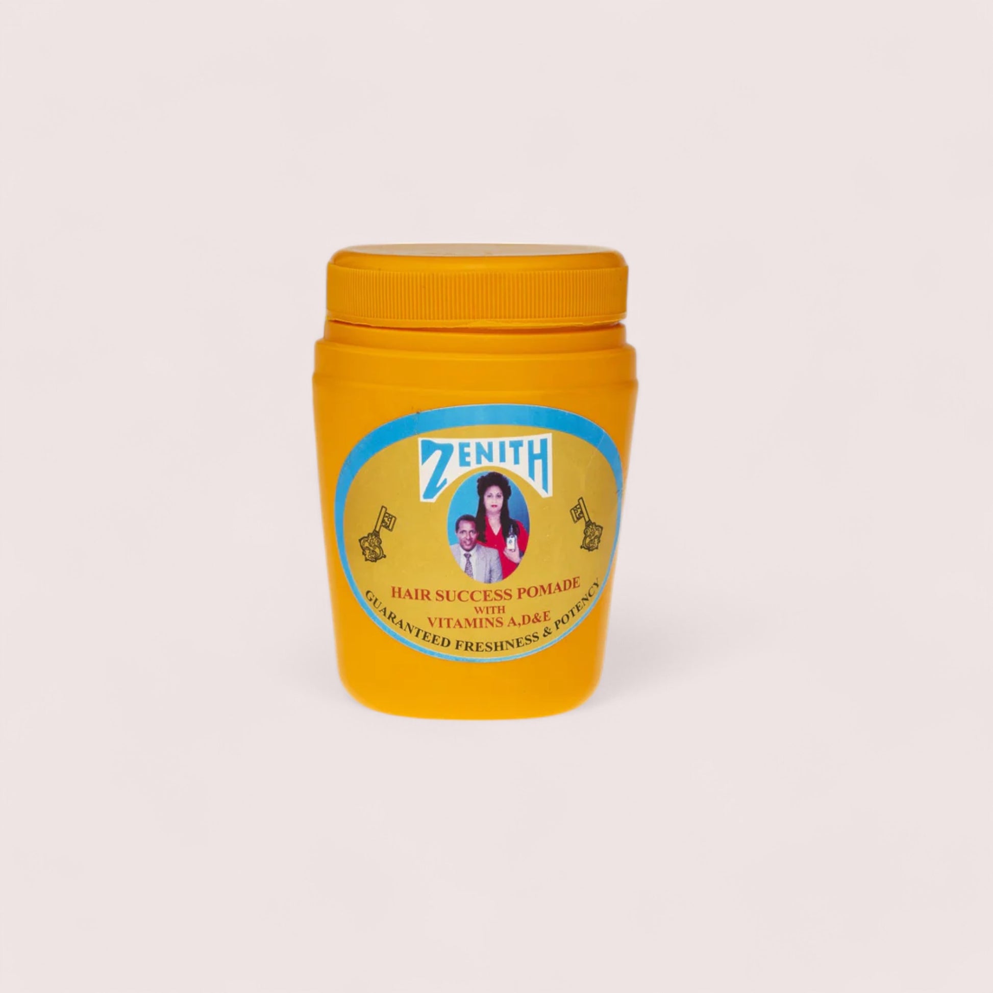 A yellow container of Zenith Habesha Hair Food Oil with a label featuring text and an image of a person.