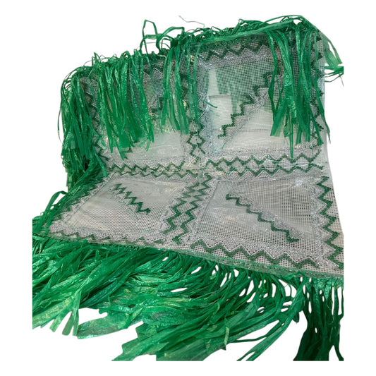 A traditional green coffee ceremony mat with intricate designs and fringes.