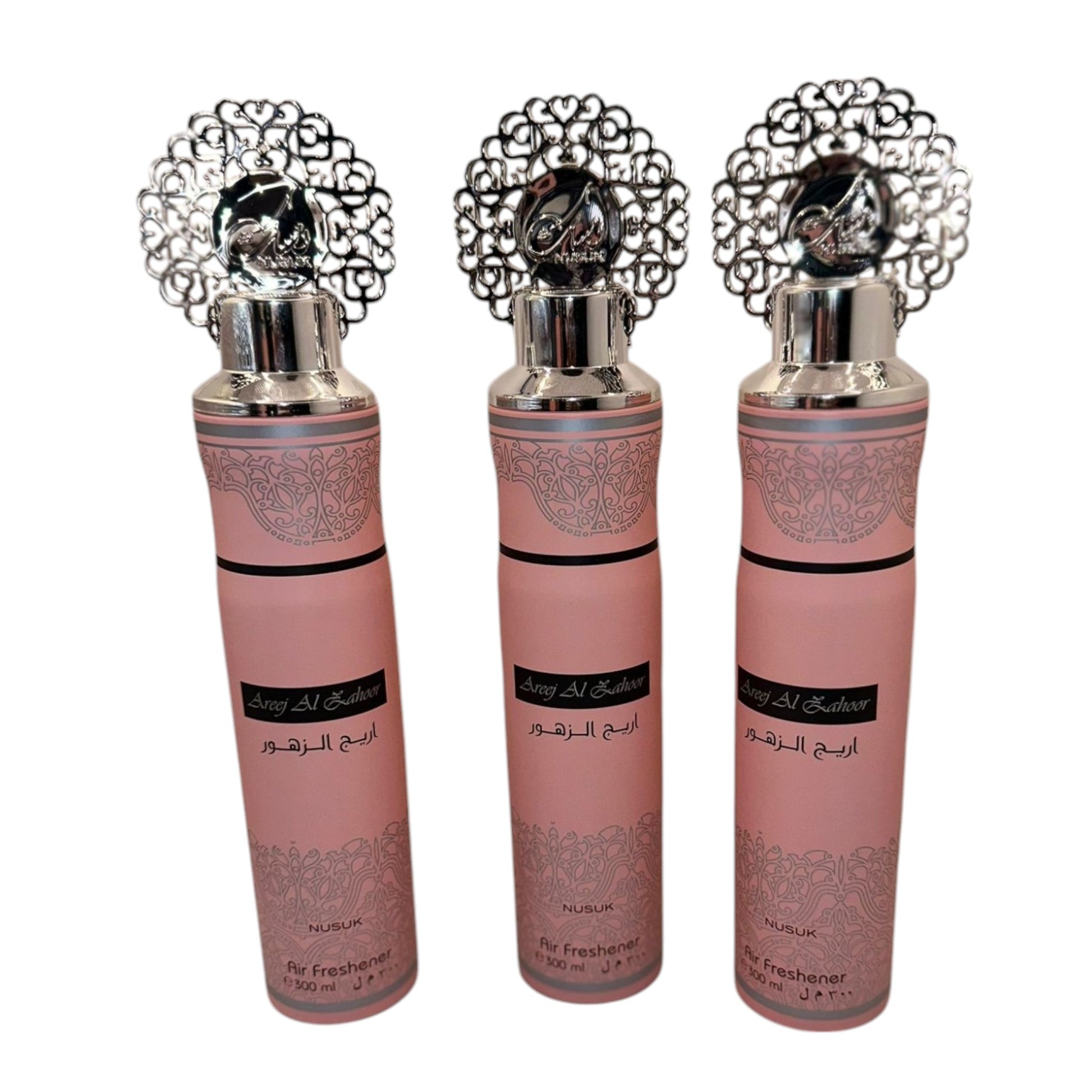 Three bottles of Al Ajeer air freshener with decorative caps, displayed against a white background.