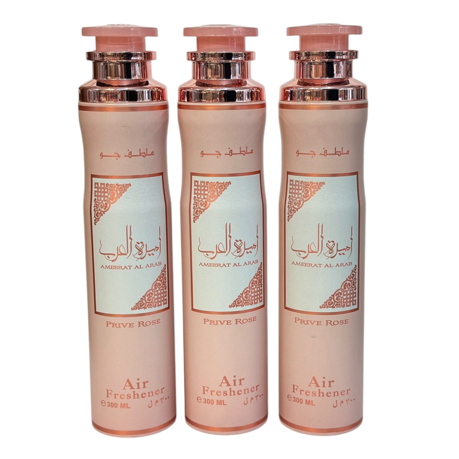 Three bottles of Ameerat Al Arab air freshener with pink and white packaging, labeled in Arabic, in a row.