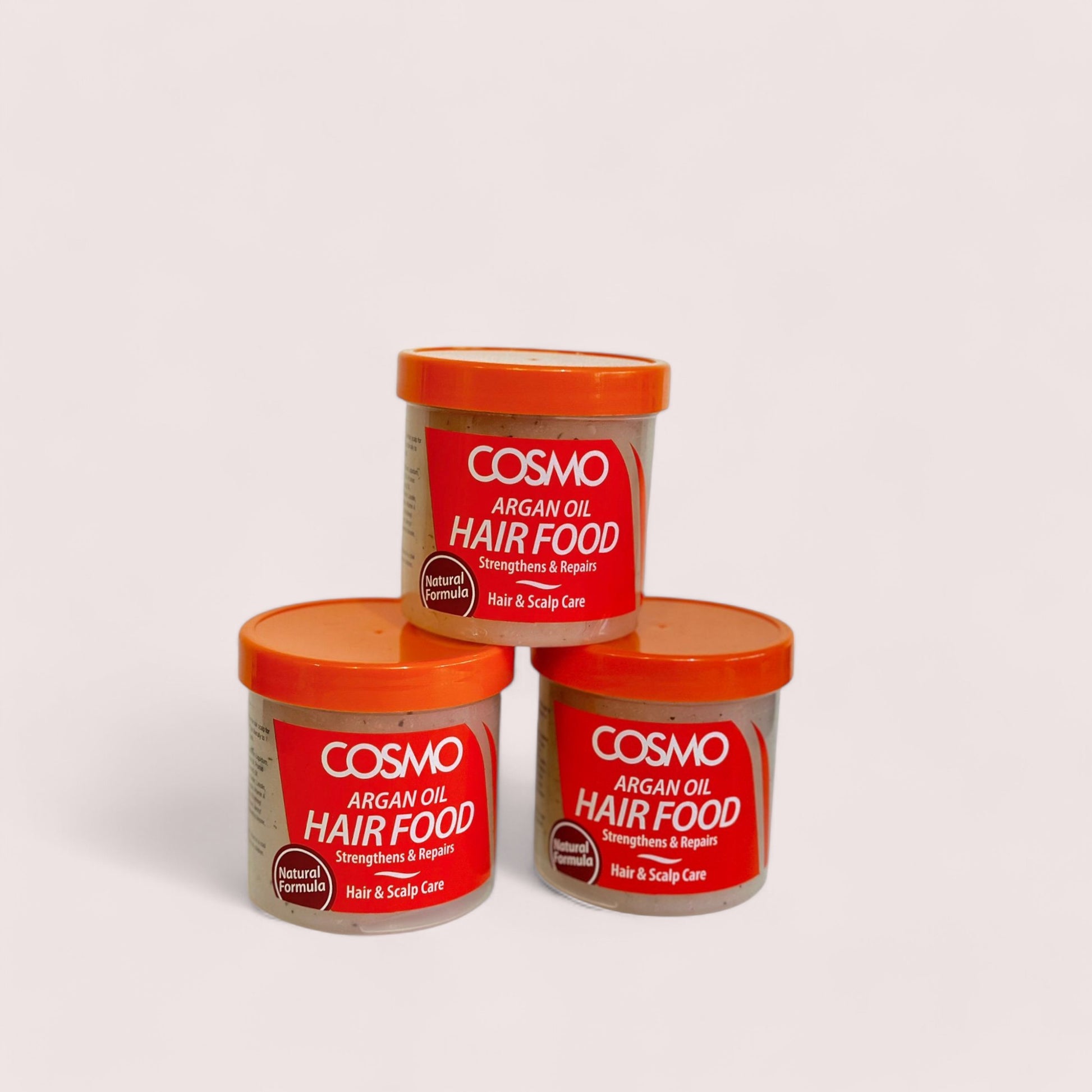 Three containers of Cosmo Argan Hair Food Oil with red lids, arranged against a white background.