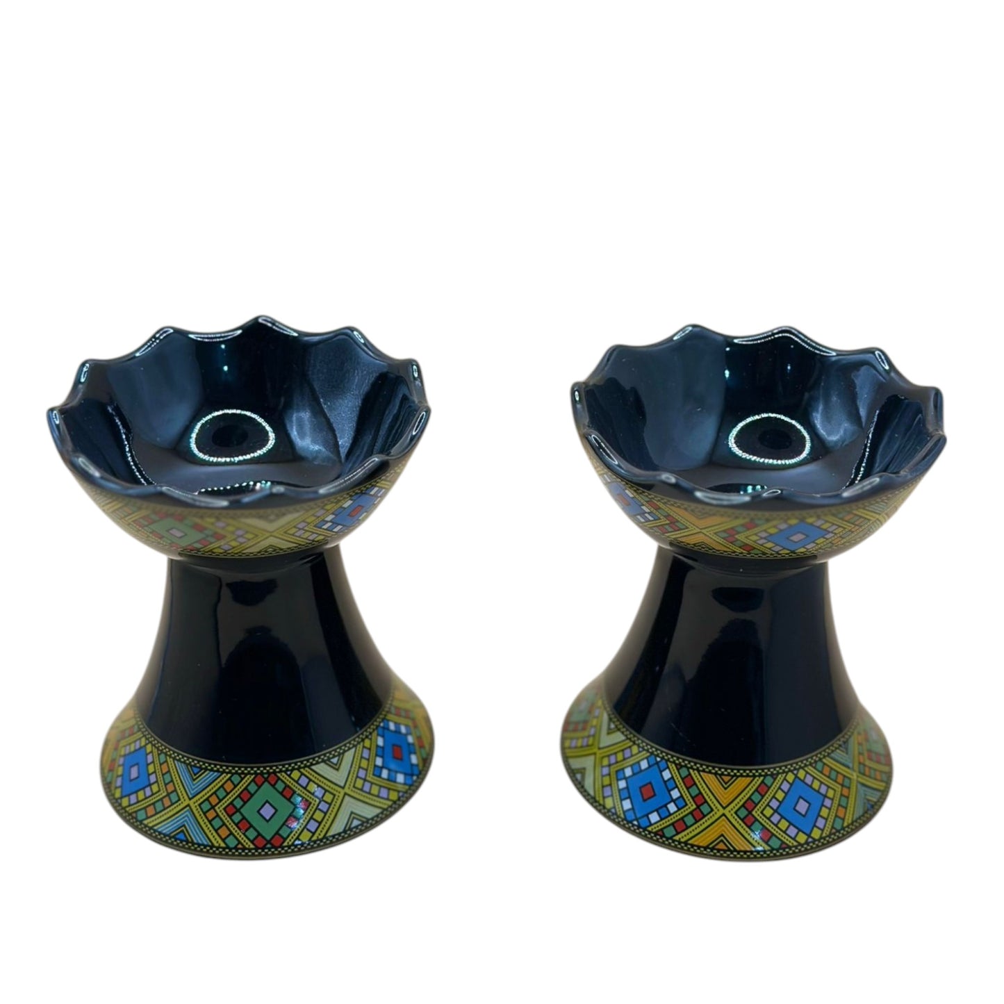Two traditional ceramic incense burners with geometric patterns in black, blue, and yellow colors.