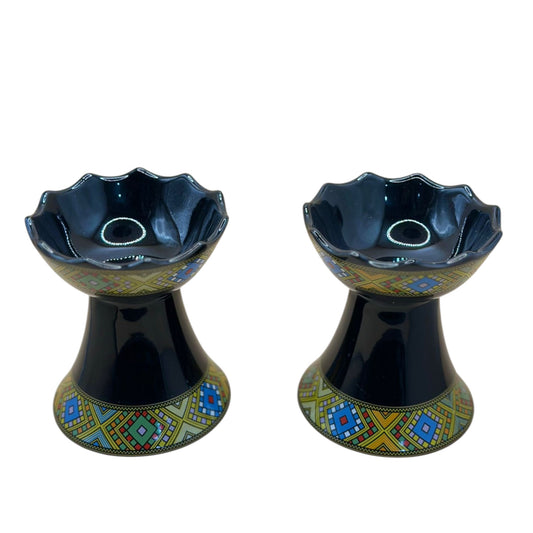 Two traditional ceramic incense burners with geometric patterns in black, blue, and yellow colors.