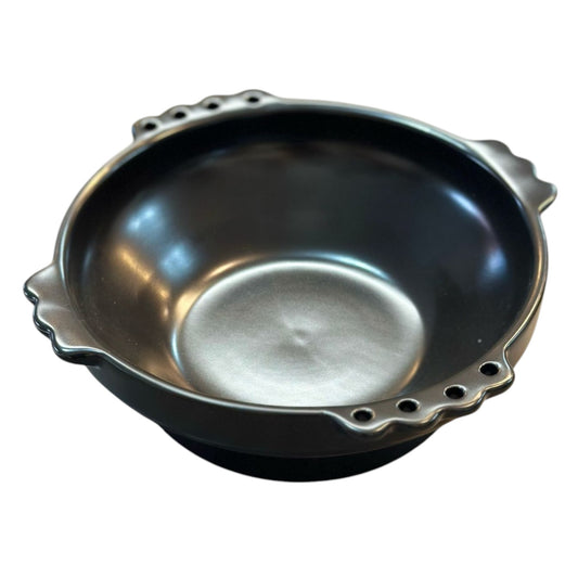 A medium-sized black ceramic Habesha Taba pot with a round shape and what appears to be a pouring lip on the side.