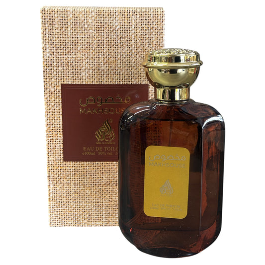 Perfume bottle with gold cap and brown glass, next to a textured brown box with branding.