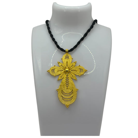 A gold-plated cross pendant on a black thread necklace displayed on a mannequin.