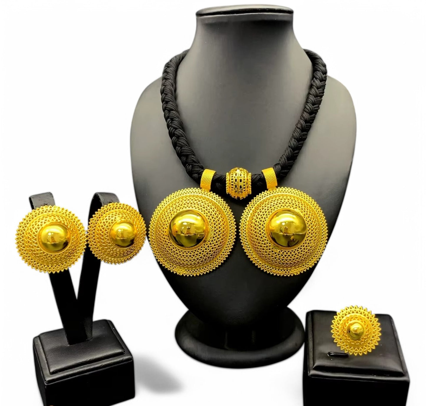 A gold-plated Habesha jewellery set displayed on a mannequin, including a necklace, earrings, and a ring, with the mannequin wearing a black dress.