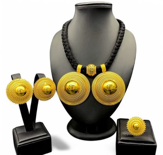 A gold-plated Habesha jewellery set displayed on a mannequin, including a necklace, earrings, and a ring, with the mannequin wearing a black dress.