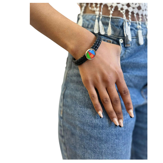 A person wearing a handmade leather bracelet featuring the colors of the Eritrean flag.