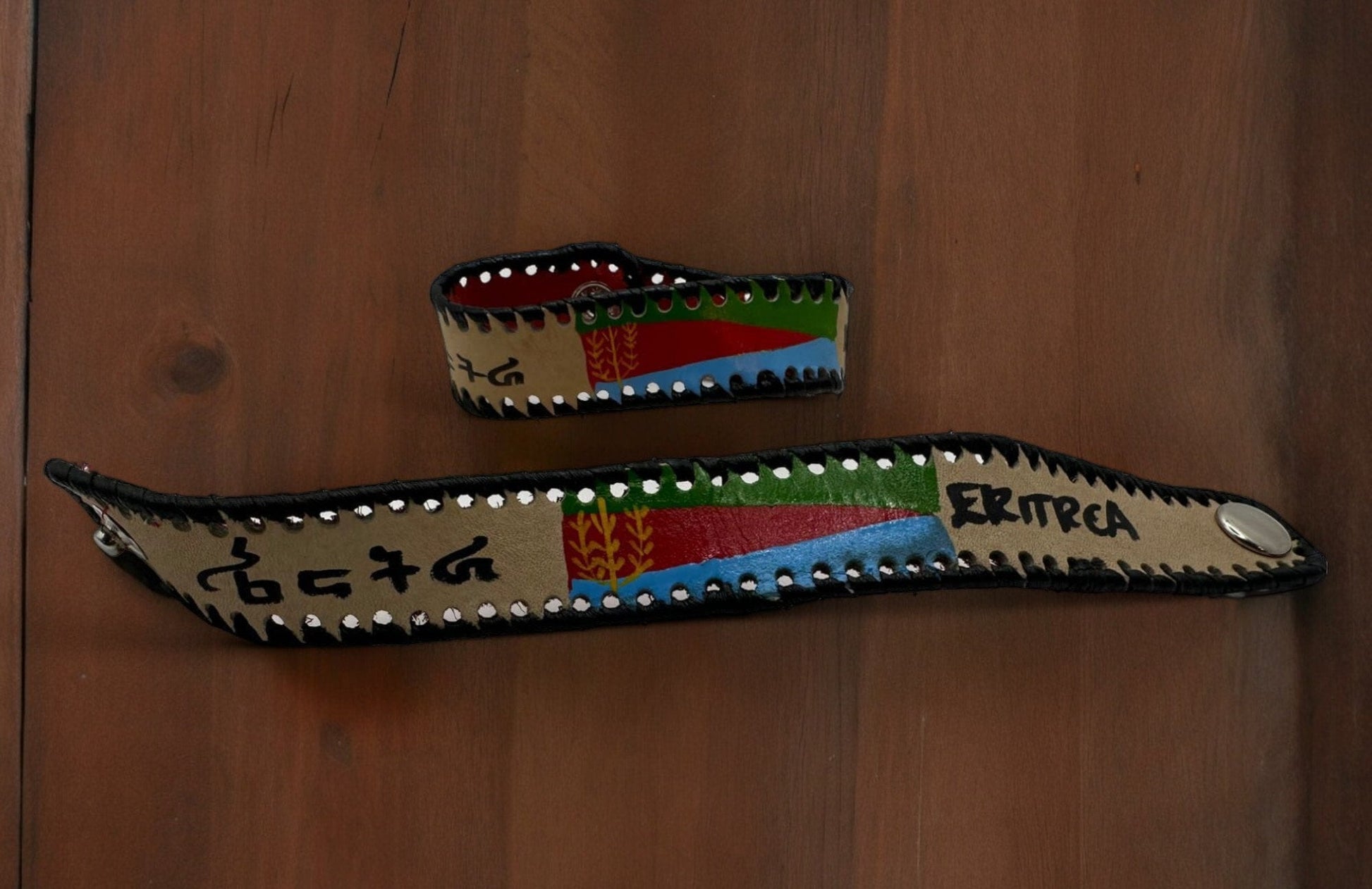 A handmade leather bracelet featuring the colors and flag symbols of Eritrea.