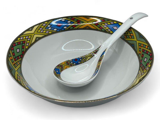 A ceramic bowl with a traditional Habesha design, featuring a geometric pattern in multicolor, with a white spoon inside.