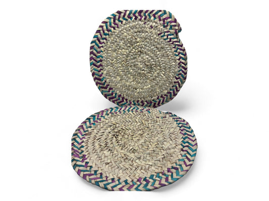 Two traditional woven palm leaf fire fans with multicolored edges.