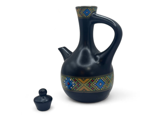 A black ceramic Habesha traditional coffee pot with geometric patterns, accompanied by a small lid.