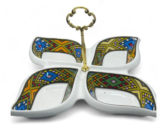 A ceramic snack serving set with geometric patterns in white, gold, and multiple colors, featuring a central decorative metal piece.