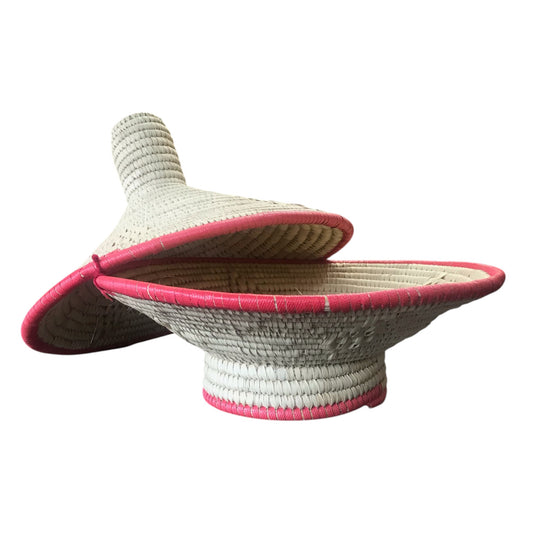 Woven sun hat with pink trim on a white background