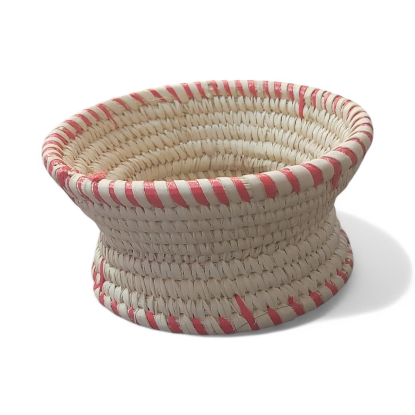 A traditional Habesha Jebena holder made from dried palm leaves, featuring a coiled design with red and white striped detailing around the edge.