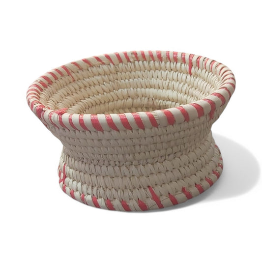 A traditional Habesha Jebena holder made from dried palm leaves, featuring a coiled design with red and white striped detailing around the edge.