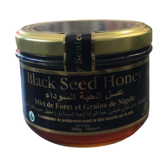 Jar of black seed honey with gold lid on a white background